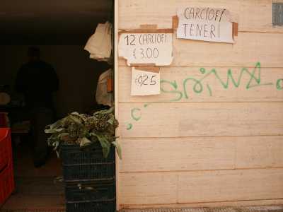 Passiamo sul lato sinistro della strada e notiamo sul muro alcuni fogli che fungono da insegna: indicano la vendita di �carciofi teneri�